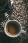 Безпосередньо над чашкою кави на сільському дерев'яному столі — стокове фото