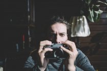 Photographer posing with vintage camera and looking at camera — Stock Photo