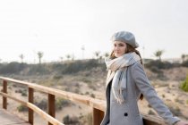 Pretty woman leaning at wooden handrail of boardwalk — Stock Photo