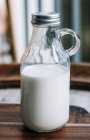Fermer bouteille en verre de lait frais — Photo de stock