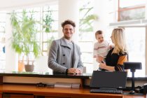 Smiling family with son waiting at hotel reception — Stock Photo