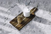 Stillleben von Milchflasche und Keksen auf Holztisch. — Stockfoto