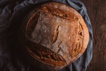Rustikales Laib handwerkliches Brot auf dunkler Leinwand — Stockfoto
