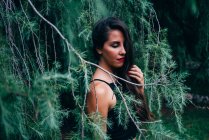 Pretty woman with closed eyes posing in fir branches — Stock Photo