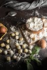Directly above view of raw gnocchi and ingredients on cutting board — Stock Photo