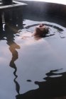 Mujer rubia alegre tumbada y relajante en la bañera de inmersión exterior - foto de stock
