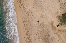 Vista aérea da mulher correndo na praia vazia no dia ensolarado . — Fotografia de Stock