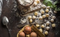 Directly above view of raw gnocchi and ingredients on kitchen counter — Stock Photo