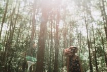 Donna allegra posa nella foresta illuminata dal sole — Foto stock
