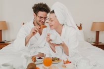 Casal romântico tomando café da manhã na cama do hotel — Fotografia de Stock