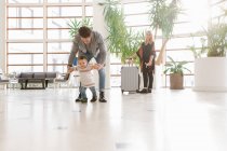 Junger Vater läuft mit Kind in Hotelhalle — Stockfoto