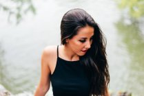 Brunette woman looking aside on background of river — Stock Photo