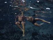 Vista submarina a los hombres nadando en el océano - foto de stock