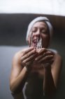 Mujer alegre en la bañera de inmersión exterior que muestra el carámbano a la cámara . - foto de stock