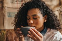 Donna che beve tazza di caffè con gli occhi chiusi — Foto stock