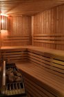 Interior of small wooden sauna room with seats and furnace. — Stock Photo