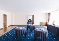 Interior de color azul de gran salón con mesas y copas servidas . - foto de stock