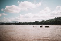 Човен, що пливе в брудному тропічному озері — стокове фото