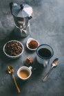 Xícara de café e ingredientes com cafeteira na mesa — Fotografia de Stock