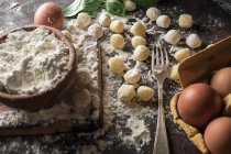 Direkt über der Ansicht von rohen Gnocchi und Zutaten auf dem Küchentisch — Stockfoto