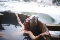 Cheerful topless woman in outside plunge tub relaxing with eyes closed — Stock Photo