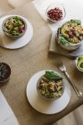 Bowls of salads with quinoa and red beans on table — Stock Photo