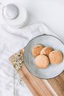 Delicious cookies in plate by milk bottle — Stock Photo