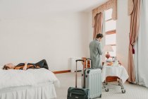 Мужчина и женщина с чемоданами отдыхают в номере отеля . — стоковое фото