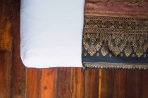 Crop bed with ornate oriental blanket — Stock Photo