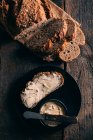 Rebanada de pan fresco rústico con mantequilla - foto de stock