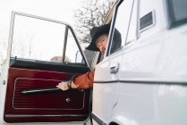 Homem pensativo de chapéu sentado no carro branco vintage uma porta de fechamento — Fotografia de Stock