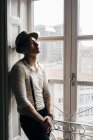 Dreamy man in vintage clothes posing at window — Stock Photo