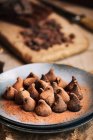 Натюрморт шоколадных трюфелей в деревенской тарелке — стоковое фото