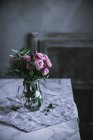 Куча розовых роз в стеклянной вазе на столе — стоковое фото
