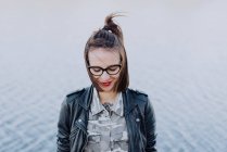 Stylische Frau mit Brille posiert gegen ruhige See — Stockfoto