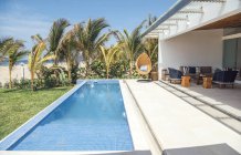 Esterno della villa con piscina e lettini — Foto stock