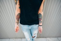 Татуированная женщина у металлической стены — стоковое фото