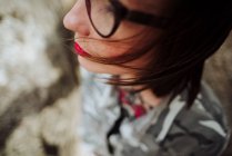 Обрізати жінку в окулярах позує на камені — стокове фото