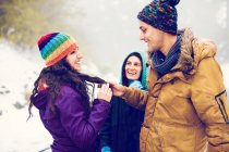 Cheerful friends having time in winter woods — Stock Photo