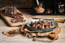 Natura morta di tartufi e cioccolato vario su tavolo rustico — Foto stock