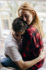 Junges Paar umarmt sich romantisch am Fenster — Stockfoto