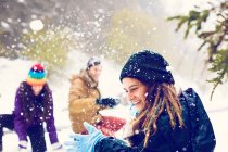 Happy friends playing snowballs in snowy woods — Stock Photo