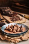 Still life of chocolate truffles in rustic ceramic plate — Stock Photo