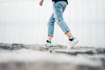 Section basse de la jeune femme marchant sur la chaussée — Photo de stock