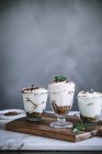Sweet desserts tiramisu in glasses on table — Stock Photo