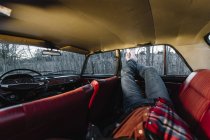 Colheita pernas masculinas fora da janela do carro vintage — Fotografia de Stock