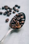 Vista de cerca de granos de café en cuchara retro - foto de stock