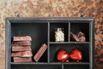 Crop wooden rustic box with various chocolates on shelves — Stock Photo
