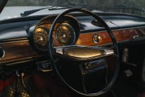 Dashboard with wooden panels and steering wheel of retro car. — Stock Photo
