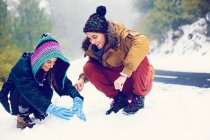 Happy couple making snowman at roadside in woods — Stock Photo